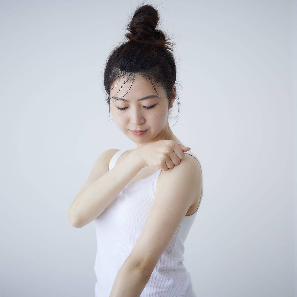 女性が肩にMy.Supporter ミネラルケアクリームを塗るシーン。マッサージしながら肌に潤いを与える美容クリーム。