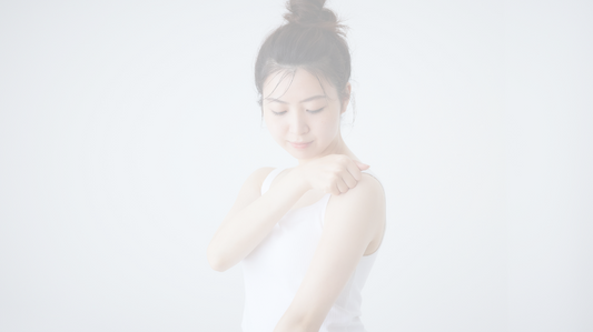 画像は非常に明るく、白っぽいトーンで表現されています。女性が白いタンクトップを着ており、腕に化粧品を塗っているように見えます。これは「My.Supporter化粧品」の正しい使い方を示すイメージとして使用されている可能性があります。  

**代替テキスト（alt text）:**  
「My.Supporter化粧品の正しい使い方を実践する女性」